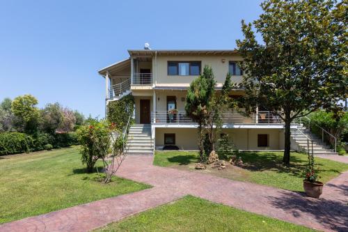 a house with stairs and trees in front of it at The Olympus Garden Beach House in Litochoro