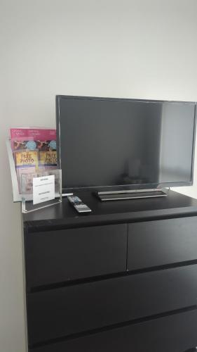 a black dresser with a laptop on top of it at Kingwood apartaments in London