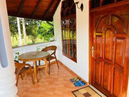 a room with a wooden door and a table and chairs at ANTONIO TRANSIT KATUNAYAKE in Katunayake