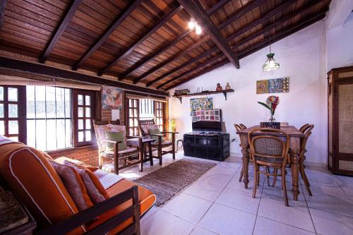 a living room with a couch and a table and a stove at Casa com Piscina a 100 m. de Camburizinho in Camburi