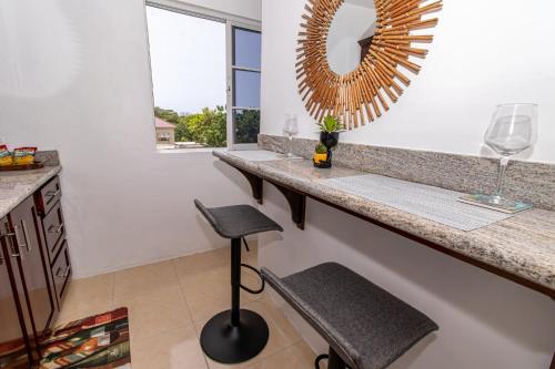 a bathroom with a counter and a mirror and a stool at Runaway Bay Gem Suite in Runaway Bay