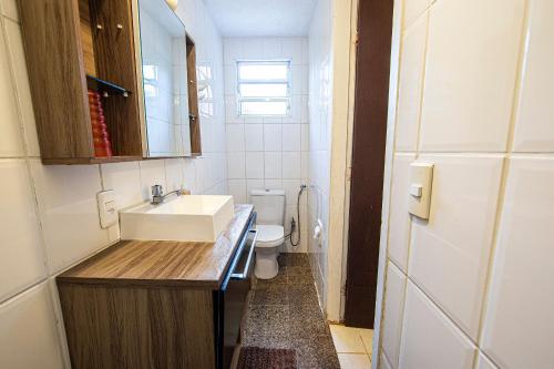a small bathroom with a sink and a toilet at Casa com Piscina a 100 m. de Camburizinho in Camburi