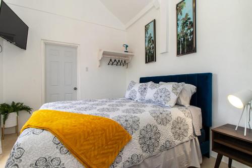 a bedroom with a bed with a yellow blanket on it at Runaway Bay Gem Suite in Runaway Bay