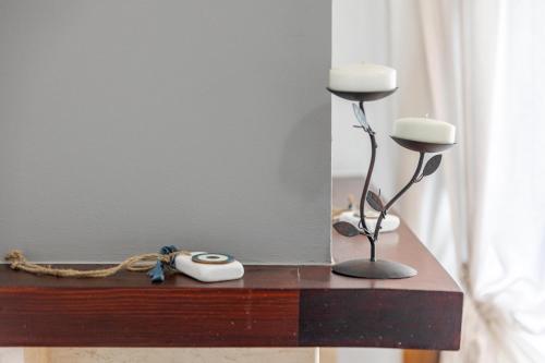 a table with a lamp and a clock and a mirror at The Olympus Garden Beach House in Litochoro