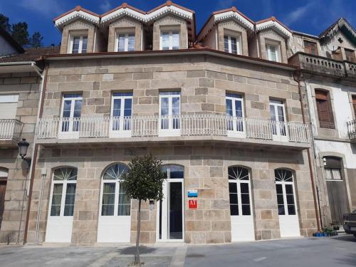 un gran edificio de piedra con balcón en la parte superior. en Reginita Apartamentos, en Arbo