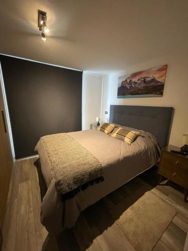 a bedroom with a bed and a painting on the wall at PuertoVaras410 in Puerto Varas