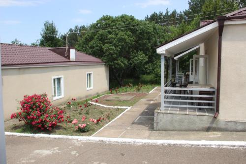 une maison avec un jardin de fleurs devant elle dans l'établissement Hotel Lori Berd, à Stepanavan