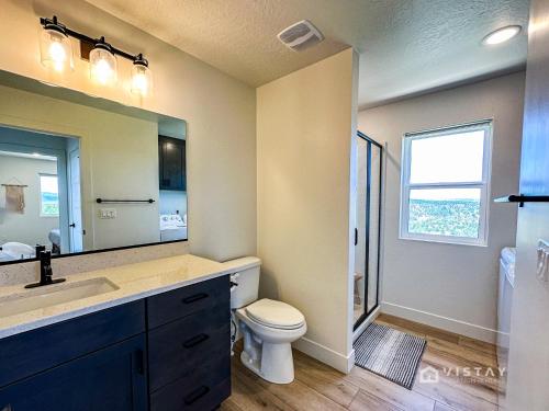 ein Badezimmer mit einem Waschbecken, einem WC und einem Spiegel in der Unterkunft Bryce View Cabin - New Cabin With Amazing Views! in Alton