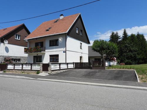 a white house with a parking lot in front of it at Zimski san in Ravna Gora