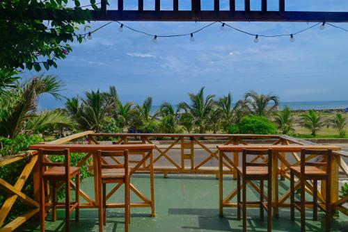 a group of wooden tables and chairs on a beach at Casa Hotel Terraza del Cabrero in Cartagena de Indias