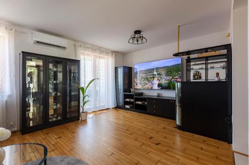sala de estar con TV de pantalla plana grande en Villa Andrea, en Koper