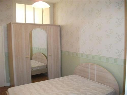 une petite chambre avec un lit et un miroir dans l'établissement Ducos, à Agen