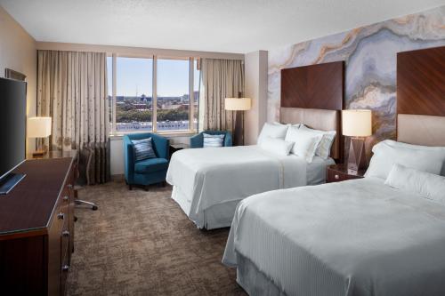 a hotel room with two beds and a desk at The Westin Savannah Harbor Golf Resort & Spa in Savannah