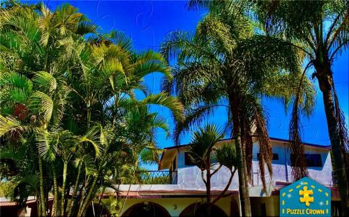 a group of palm trees in front of a building at Finca El Quijote con alberca y 6 cuartos in Atlixco