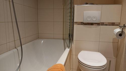 a bathroom with a tub and a toilet and a shower at Ruhe pur am Golfplatz Stromberg in Stromberg