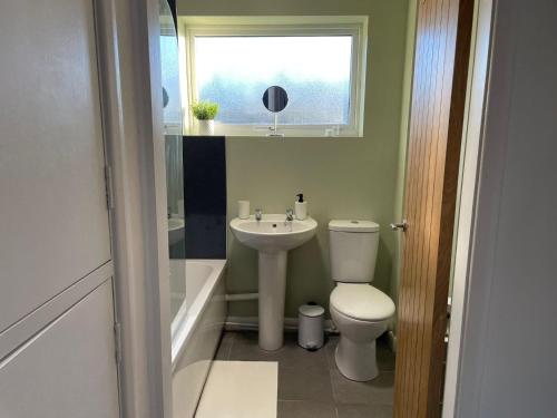 a bathroom with a toilet and a sink and a window at Bottesford Apartments in Brumby