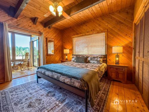 ein Schlafzimmer mit einem Bett in einer Blockhütte in der Unterkunft Runway Cabin Retreat With Private Hot Tub! in Duck Creek Village