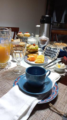 a table topped with plates of food and drinks at Pousada Blumenau in Blumenau