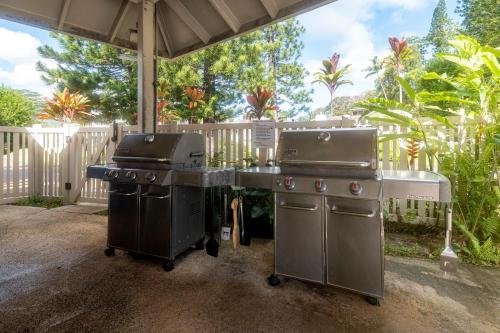 two bbqs and a grill in a backyard at Makai Club Resort in Princeville
