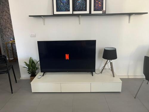 una TV a schermo piatto seduta sopra un centro di intrattenimento bianco di Cinque Terre Luxury Home a La Spezia