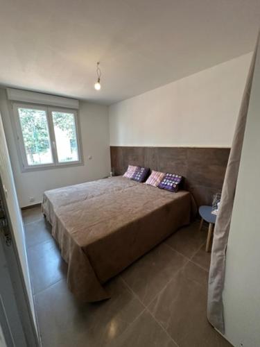 une chambre avec un grand lit et une fenêtre dans l'établissement les gites du parc animalier de ginasservis, à Ginasservis