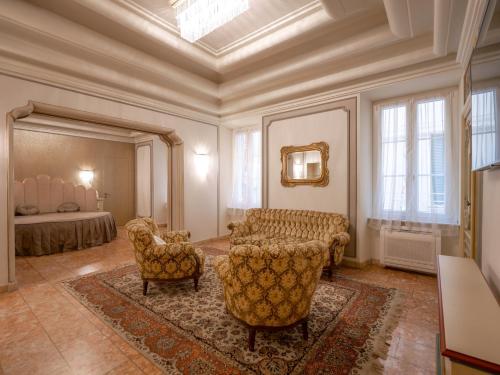 ein Wohnzimmer mit einem Sofa, Stühlen und einem Bett in der Unterkunft Casa Balzola - Suite Perla in Alassio