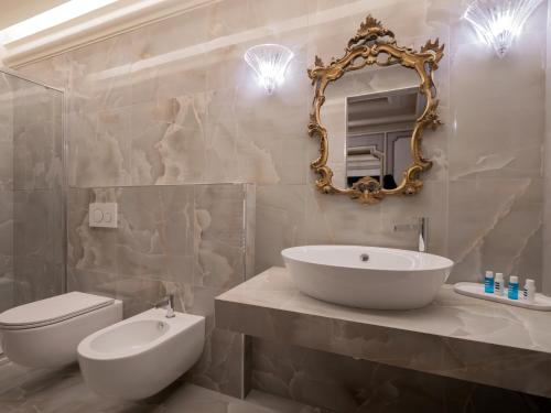 ein Badezimmer mit einem Waschbecken, einem WC und einem Spiegel in der Unterkunft Casa Balzola - Suite Perla in Alassio