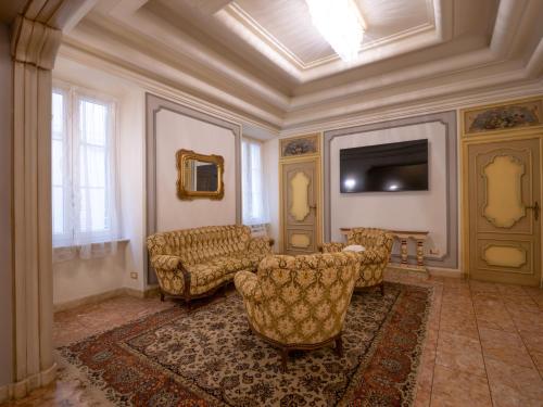 ein Wohnzimmer mit einem Sofa, Stühlen und einem TV in der Unterkunft Casa Balzola - Suite Perla in Alassio