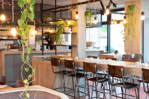 a restaurant with tables and chairs and a bar at Appartement Cosy à 10min de la Villette & du Philharmonie Paris in Le Pré-Saint-Gervais