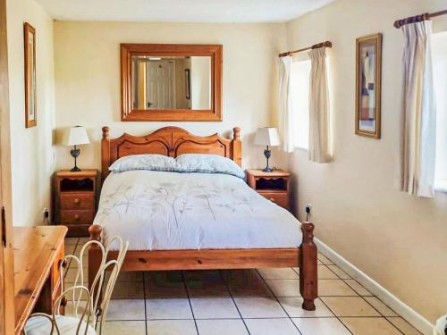 a bedroom with a bed and a desk and a mirror at Holly Lodge in Bramerton