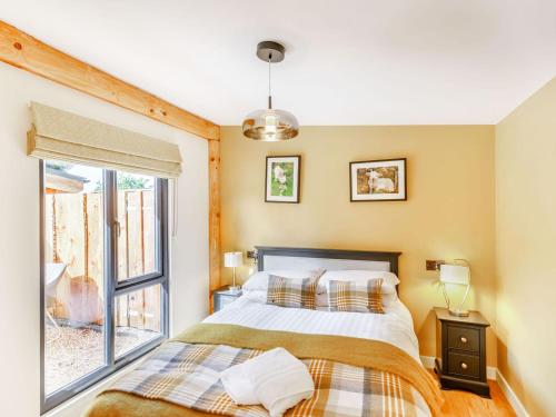 a bedroom with a bed and a window at Rhosyn - Uk40260 in Llangadfan