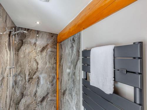 a bathroom with a shower and a stone wall at Fioled - Uk40267 in Llangadfan