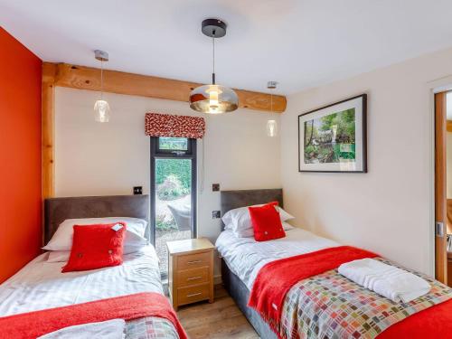 two beds in a room with red pillows at Fioled - Uk40267 in Llangadfan