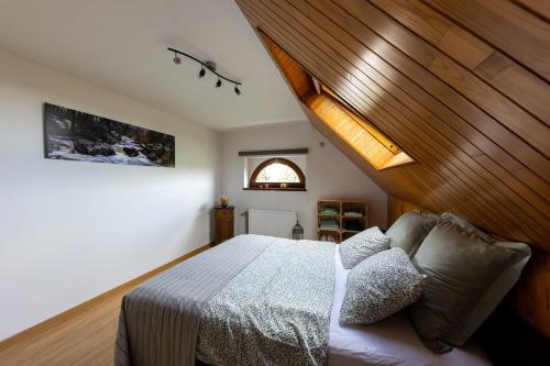 una camera con letto e soffitto in legno di L'Ermitage a Jalhay