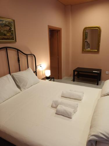 uma cama branca com duas toalhas dobráveis em Apartment Rustico em Ancient Epidavros
