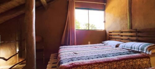 uma cama num quarto com uma janela em Cabana Africana em Imaruí