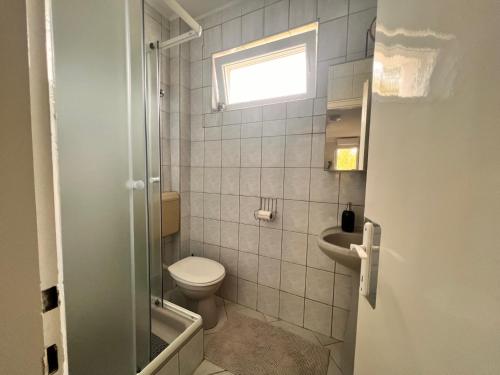 a small bathroom with a toilet and a sink at Bem Apartman in Gyenesdiás