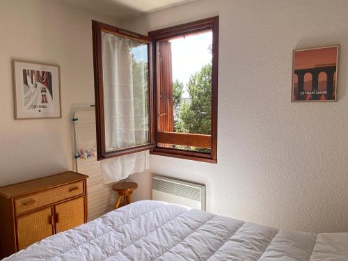 um quarto com uma cama e uma janela em Le Cantou - cocon chaleureux em Font Romeu Odeillo Via