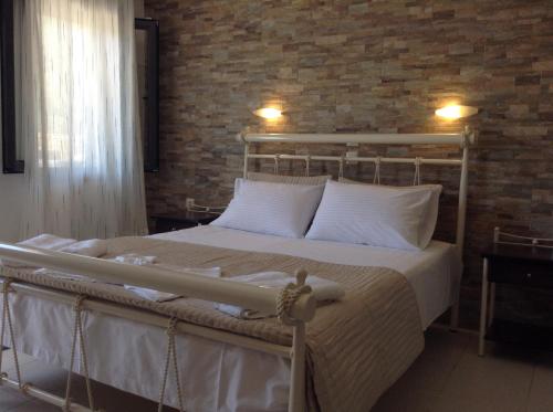 een bed in een slaapkamer met een bakstenen muur bij Villa Agapi in Parga