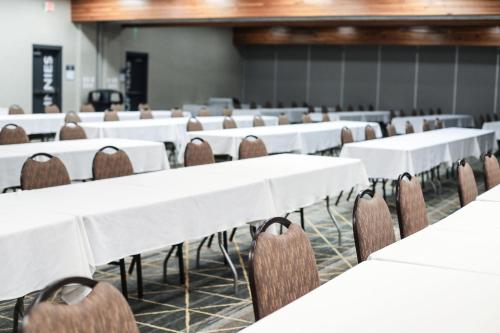 a conference room with white tables and chairs at Holiday Inn & Suites St. Cloud by IHG in Saint Cloud