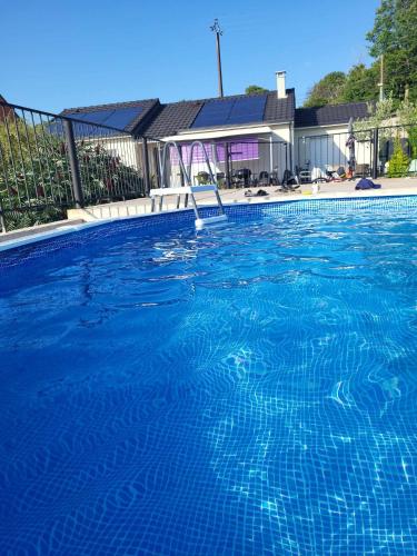une piscine avec de l'eau bleue devant une maison dans l'établissement Grande maison la Merasel, au Vigan
