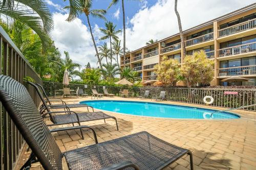 a resort swimming pool with chairs and a building at Maui Vista 1210 in Kihei