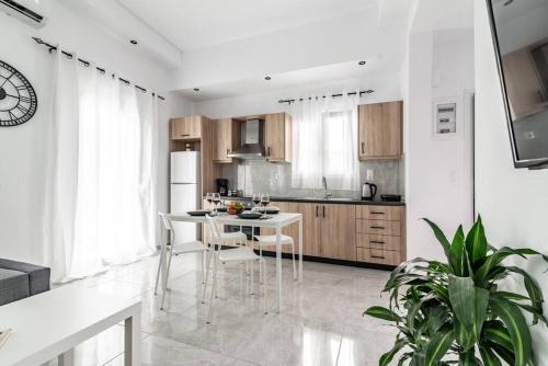 cocina blanca con mesa blanca y sillas en Modern & Stylish flat for friends & couples en Heraclión