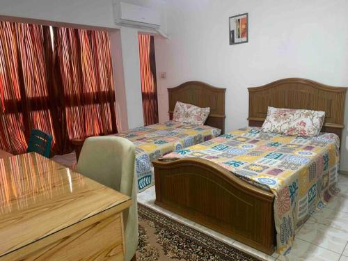 a bedroom with two beds and a table at Comfort & Relax at Maadi in Cairo