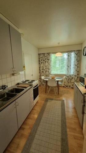 eine Küche mit einem Waschbecken und einem Tisch darin in der Unterkunft Apartment Honkatie in Kokkola