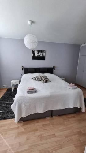 ein Schlafzimmer mit einem großen weißen Bett mit einer Lampe in der Unterkunft Apartment Honkatie in Kokkola