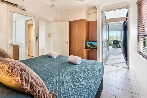 1 dormitorio con 1 cama con 2 toallas en Escape to Paradise at Oasis 1, a 2BR Central Hamilton Island Apartment with Buggy! en Isla Hamilton