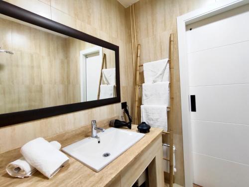 uma casa de banho com um lavatório e um espelho em Reformado a estrenar a 1 minuto estación Tren-Bus Vialia Vigo em Vigo