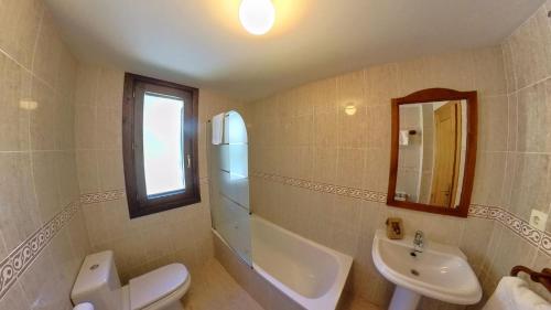 een badkamer met een toilet, een wastafel en een spiegel bij Los Avellanos - tucasaenlospirineos in Escarrilla