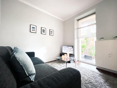a living room with a couch and a tv at Gemütliche Ferienwohnung fußläufig am Markkleeberger See in Markkleeberg